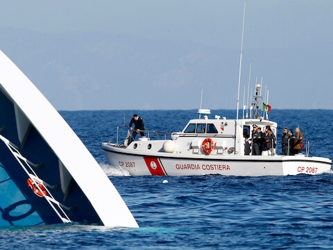 Italiaanse reddingswerkers zoeken naar overlevenden op zee.