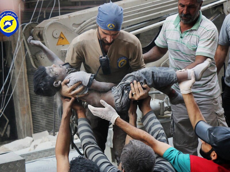 Leden van de Witte Helmen dragen het lichaam van een kind weg in het onder rebellenbewind staande deel van Aleppo.