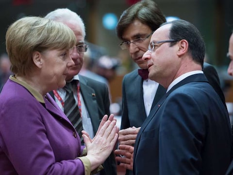 Onze premier Elio Di Rupo luistert aandachtig naar een gesprek tussen Angela Merkel en François Hollande.