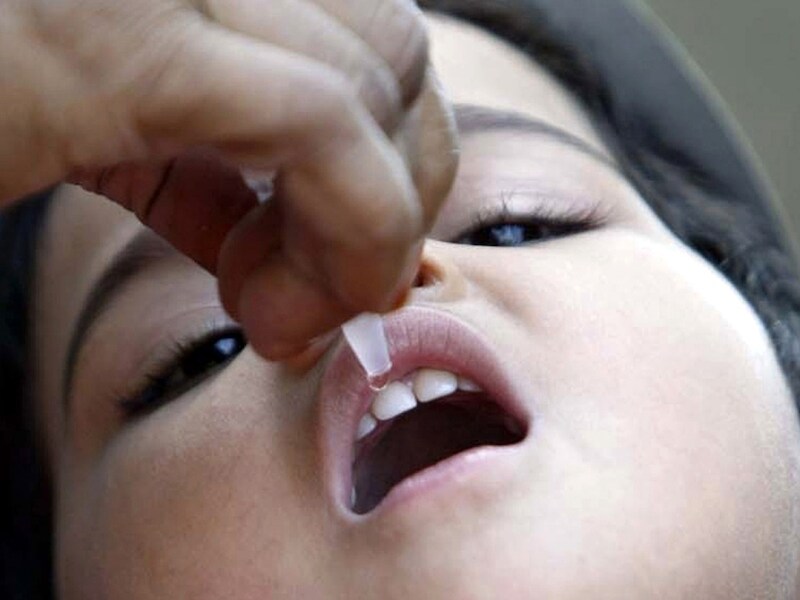 Een kind krijgt een poliovaccin in Bhopal.