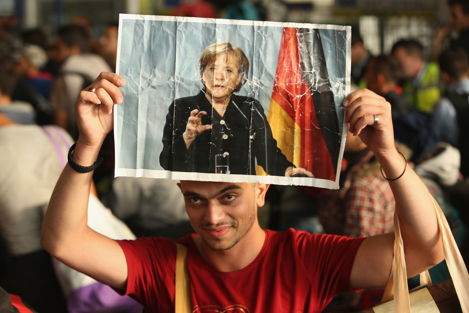 Een Syrische vluchteling met een foto van de Duitse bondskanselier Angela Merkel