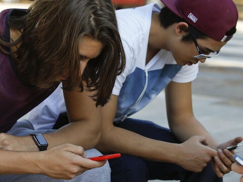 Jongeren in Sao Paulo zijn bezig met hun telefoon. WhatsApp is razendpopulair in Brazilië.