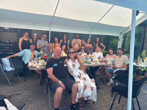 Claudia en Stef Cauwenberghs samen met de groep festivalgangers die tijdens Rock Werchter in hun tuin kampeert.
