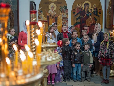 Oekraïense kinderen wachten op de mis in een orthodoxe kerk in de stad Slavjansk. Ook het Orthodoxe Pasen wordt dit weekeinde gevierd.