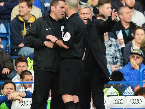 José Mourinho (r) maakt zich kwaad over een beslissing van arbiter Mike Dean (m).