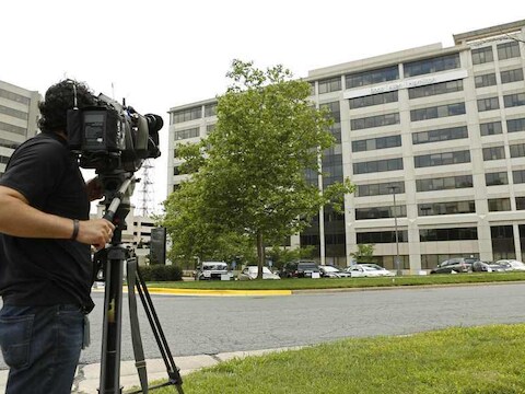 Een cameraman filmt het kantoor van Booz Allen Hamilton in McLean, in de Amerikaanse staat Virginia.