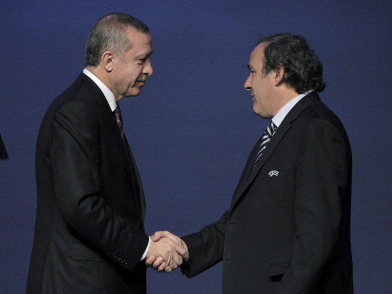 De Turkse premier Erdogan drukt UEFA-voorzitter Michel Platini de hand.
