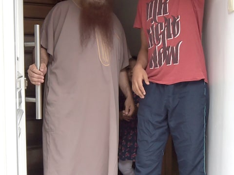Imam Shayh Alami, die illegaal in het land verblijft, en zijn zoon.