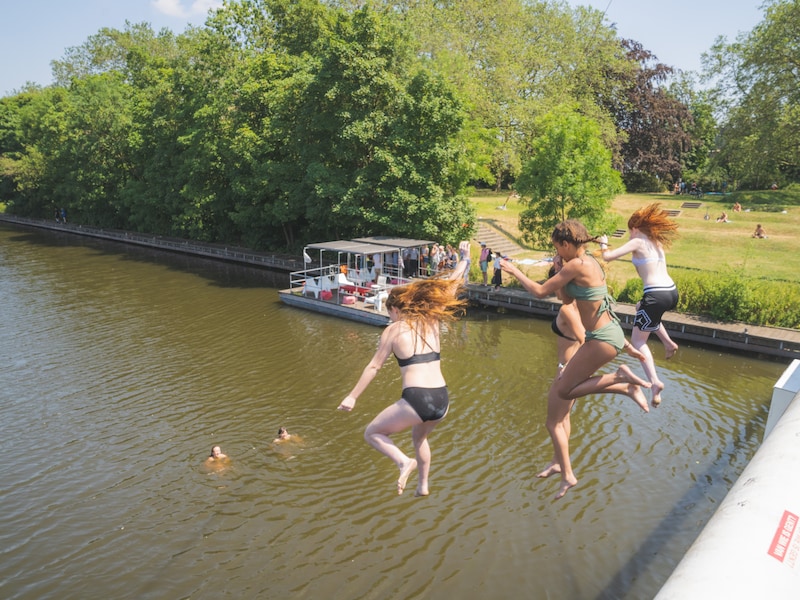Jongeren springen van de fietsbrug aan het Keizerpark in Gent.