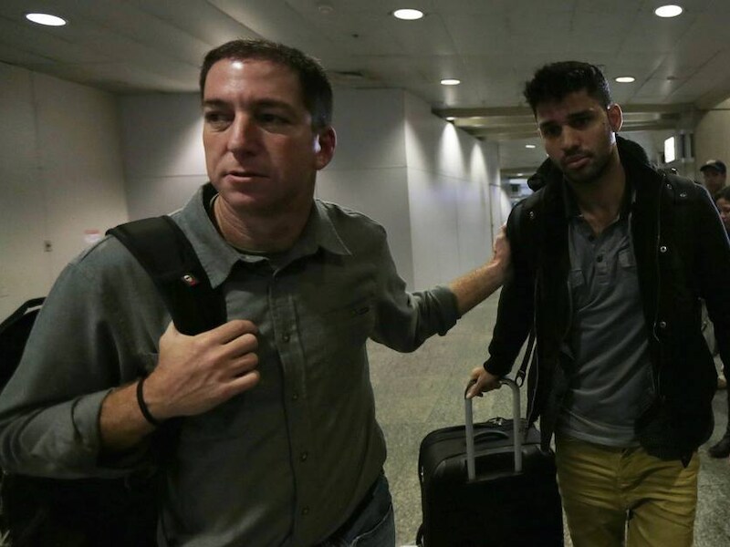 Guardian-verslaggever Glenn Greenwald (links) maandag bij het afhalen van zijn partner David Miranda op de luchthaven van Rio de Janeiro. Miranda werd zondag, onderweg vanuit Berlijn, op de Londense luchthaven Heathrow urenlang vastgehouden voor ondervraging.