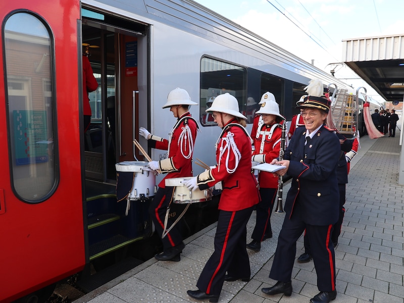 Met een volledige harmonie de trein op naar Komen. 