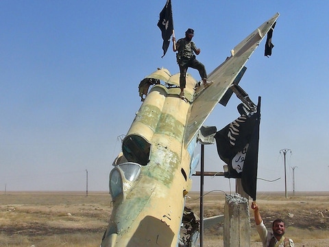 IS-strijders hijsen hun vlag in het Syrische Raqqa.