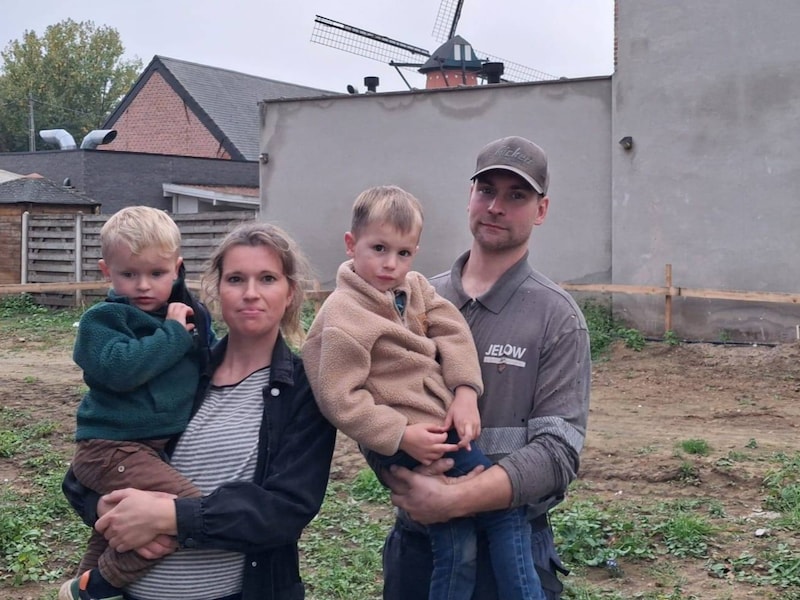Dorien Bossaerts (zwanger van hun derde kindje), Jef Huybrechts en hun twee zoontjes tonen het perceel waar ze willen bouwen. Op de achtergrond zie je de molen van Oelegem.