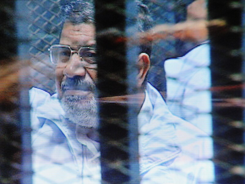 Mohammed Mursi staat in een glazen kooi in de rechtbank in Caïro.