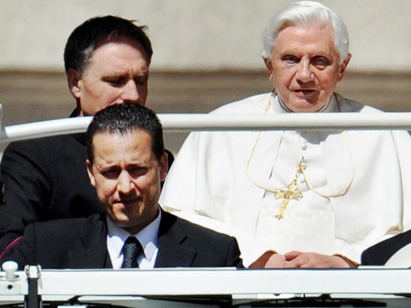 Paolo Gabriele, links vooraan, begeleidt Benedictus XVI in de pausmobiel.