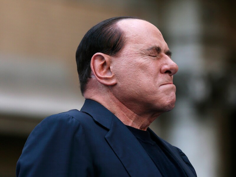 Silvio Berlusconi reageert op demonstranten bij het binnengaan van de rechtbank begin augustus, waar een zaak tegen hem diende vanwege belastingfraude.