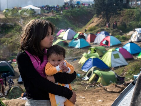 Een meisje houdt haar broertje vast in het opvangkamp aan de grens tussen Griekenland en Macedonië.