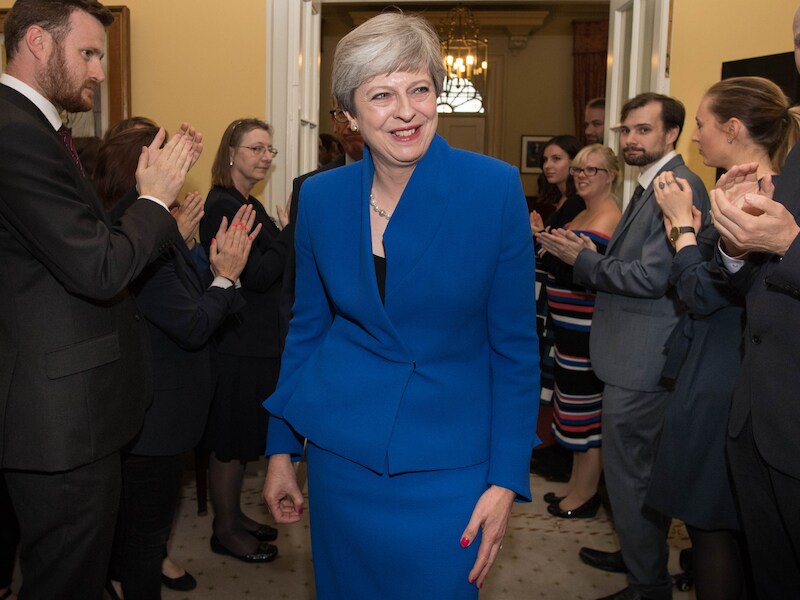 Theresa May krijgt applaus na haar onderonsje met de Queen van wie ze een nieuwe regering mag vormen, maar haar lach is eerder groen: "May wilde een meerderheid, maar ze heeft gegokt en verloren."