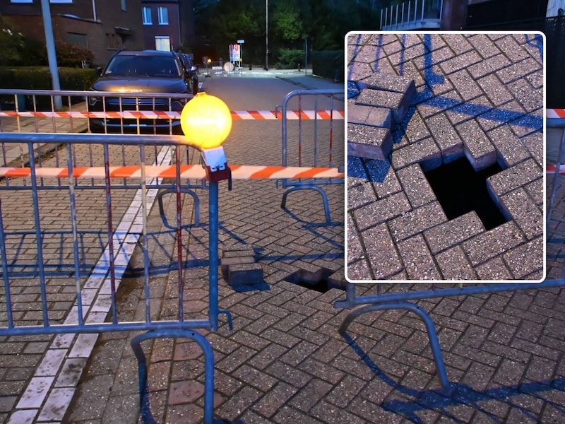 Uit voorzorg werd de volledige weg afgezet., Inzet: Enkele stenen werden verwijderd om het zinkgat in te kunnen schatten.