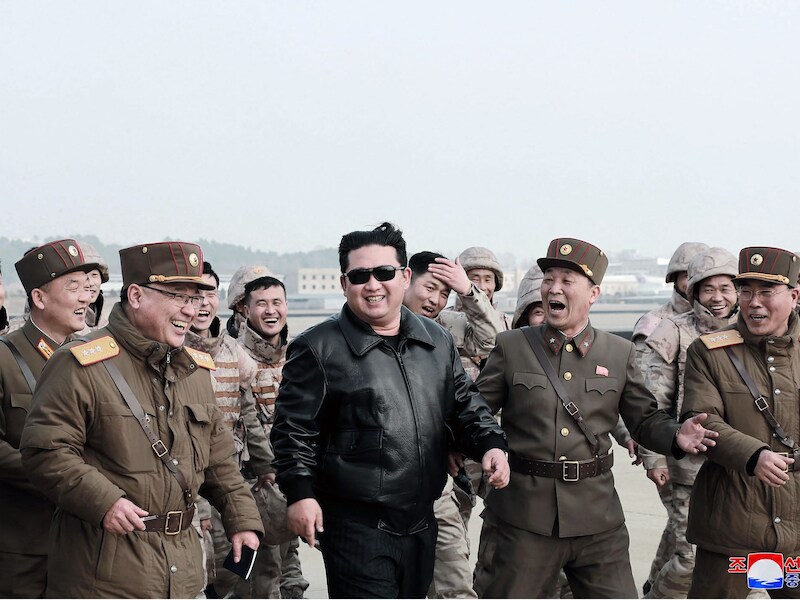 De Noord-Koreaanse leider Kim Jong-un in het gezelschap van militairen voor de lancering van een ballistische raket.