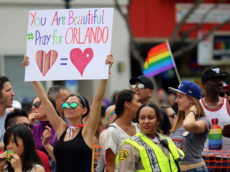 Een jonge vrouw houdt op de Gay Parade van Los Angeles een bord omhoog.