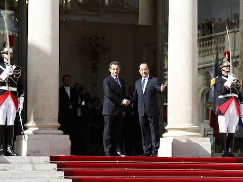 Uittredend president Nicolas Sarkozy schudt handjes met de nieuwe president François Hollande op de trappen van het Elysée, waar Hollande voortaan zal wonen.
