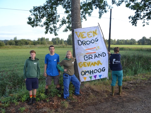 Jongeren van de JNM, Jeugdbond voor Natuur en Milieu, spandoeken opgehangen bij de Roerdompstraat te Geel. Dat deden ze om aandacht te vragen voor de droogte, die ook het aanliggende veengebied De Zegge teistert