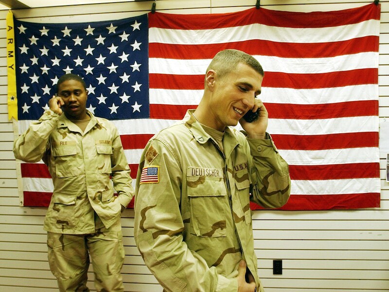 Amerikaanse soldaten in Irak bellen met hun BlackBerry.