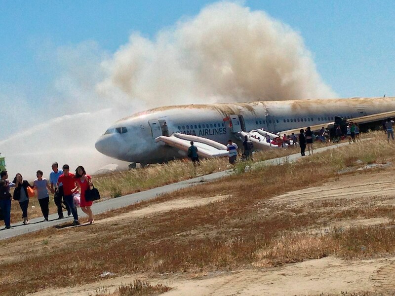 De neergestorte Boeing kort na de ramp tijdens de evacuatie. De foto is gemaakt door een van de passagiers, Eugene Anthony Rah, en ter beschikking gesteld van persbureau Reuters.