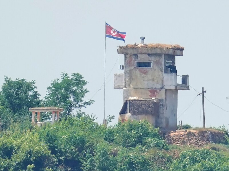 Een soldaat staat op wacht bij een Noord-Koreaanse militaire post, gezien vanuit Paju in Zuid-Korea.