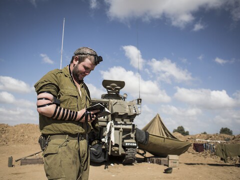 Een Israëlisch soldaat is aan het bidden bij een artilleriekanon. Een voorstel tot een staakt-het-vuren werd gisteren verworpen door Hamas.