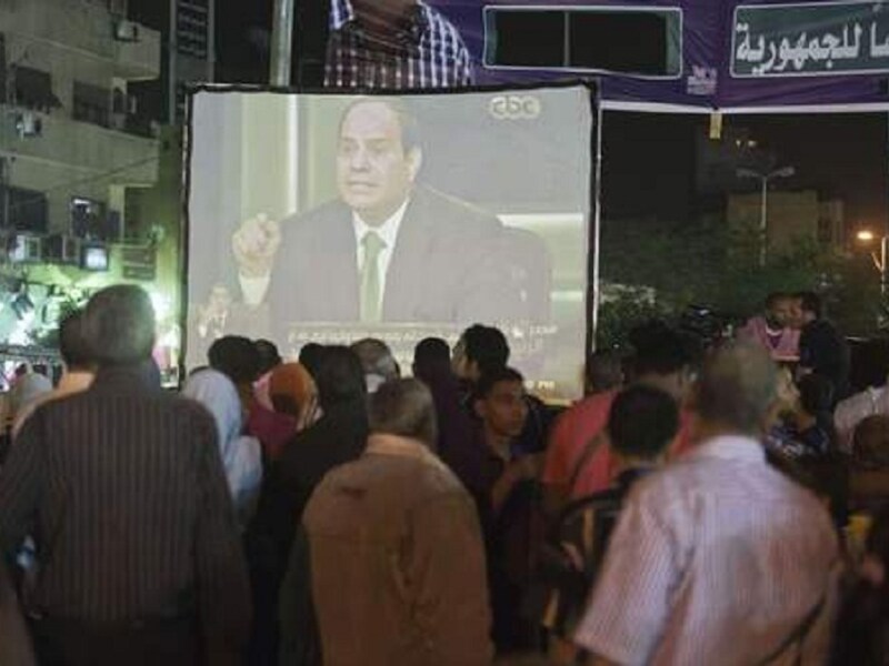Op straat in Caïro wordt het interview met Sisi op een groot scherm uitgezonden