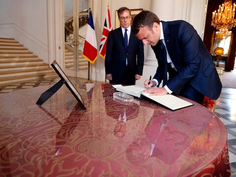 De Franse president Emmanuel Macron tekent in de Britse ambassade in Parijs het rouwregister voor de slachtoffers van de aanslag in Manchester.
