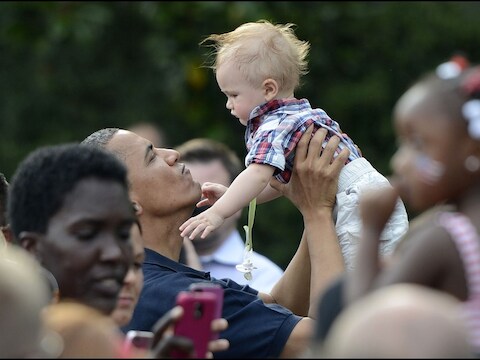 Barack Obama met een kindje tijdens de picknick bij het Witte Huis.