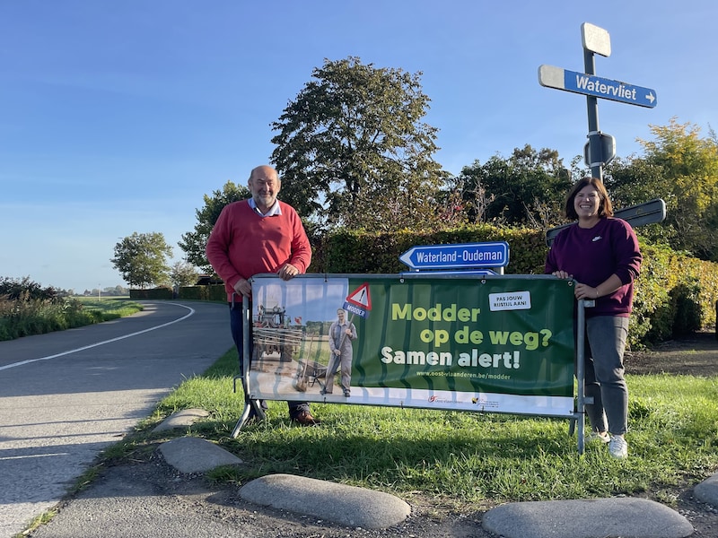 Burgemeester Patrick De Greve samen met communicatieverantwoordelijke Lien De Poorter bij de banner in de Calusstraat.