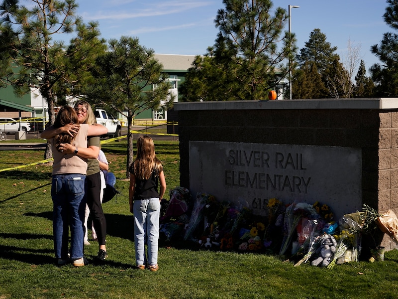 Twee vrouwen omhelzen elkaar bij basisschool Silver Rail in de plaats Bend waar gisteren drie kinderen en een lerares werden doodgeschoten door een jongen van 16 jaar oud. (16/10/26) 