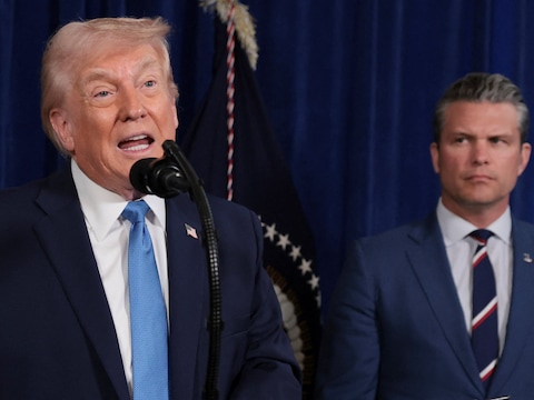 De Amerikaanse president Donald Trump, met op de achtergrond zijn minister van Defensie Pete Hegseth.