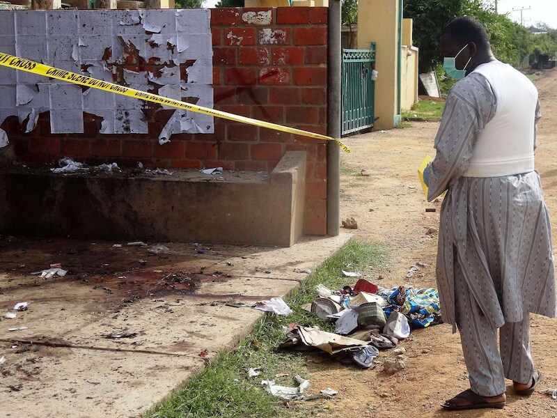 Een politieagent inspecteert de plaats van een zelfmoordaanslag in de stad Kano.