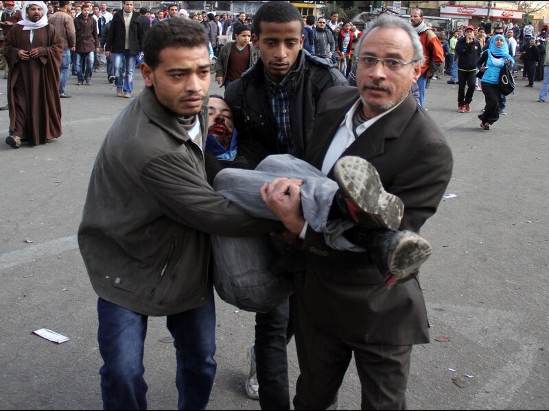 Een betoger wordt gewond weggedragen op het Tahrirplein.