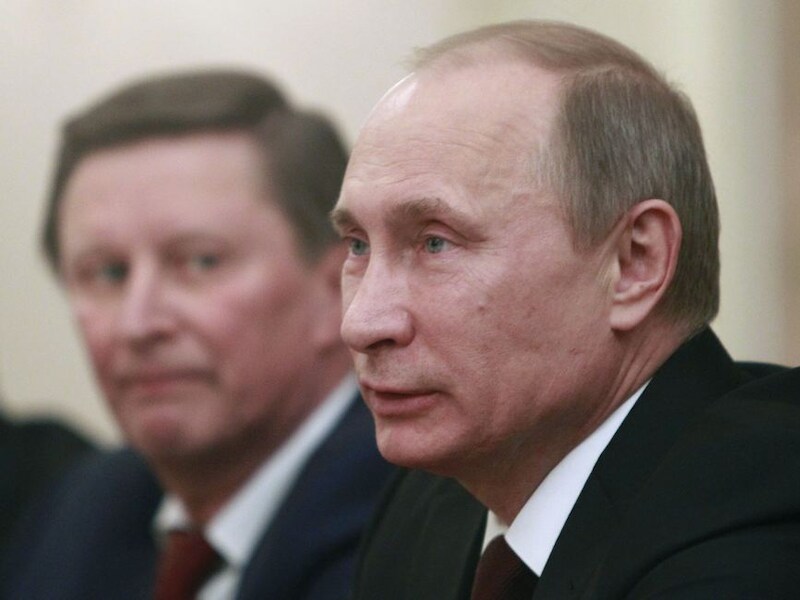 President Poetin met op de achtergrond zijn stafchef, Sergei Ivanov.