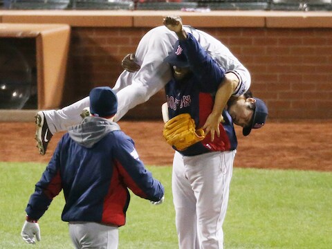 Red Sox-werper Koji Uehara gaat op de schouders bij ploeggenoot David Ortiz nadat hij Cardinals-speler Kolten Wong heeft uitgegooid.