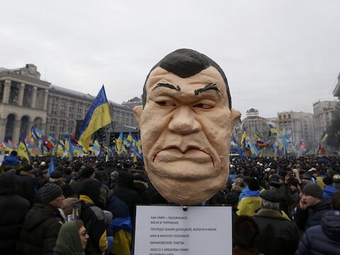 Een beeld van de president van Oekraïne tussen de demonstranten in Kiev.