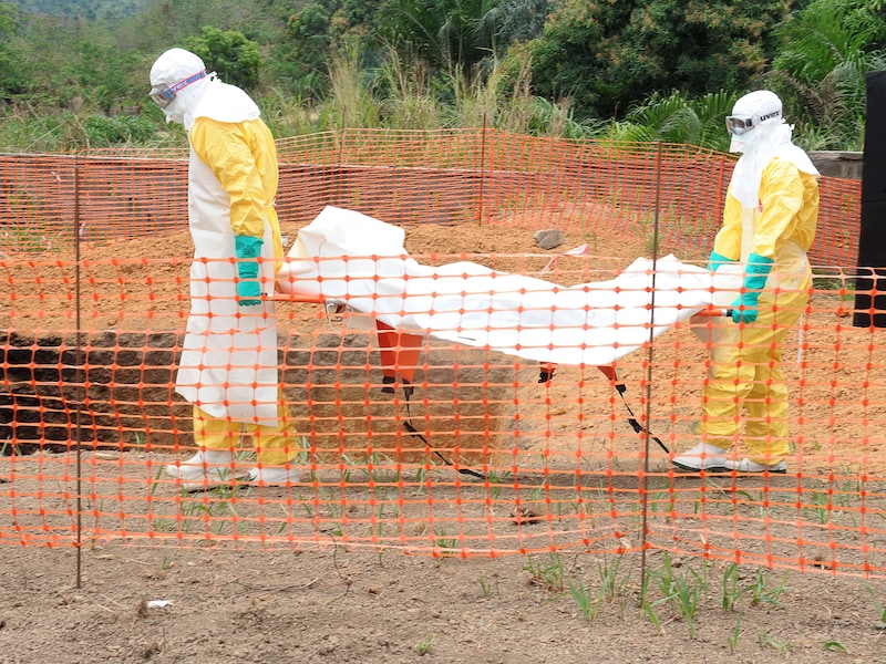 Medewerkers van Artsen zonder Grenzen begraven een slachtoffer van het ebolavirus in Guekedou, Guinee.