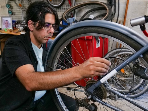 Waleed Oun Jafaar sleutelt aan fietsen in het opvangcentrum van Heusden-Zolder ondanks dat hij lijdt aan parkinson. Hij vluchtte in 2020 uit Irak.