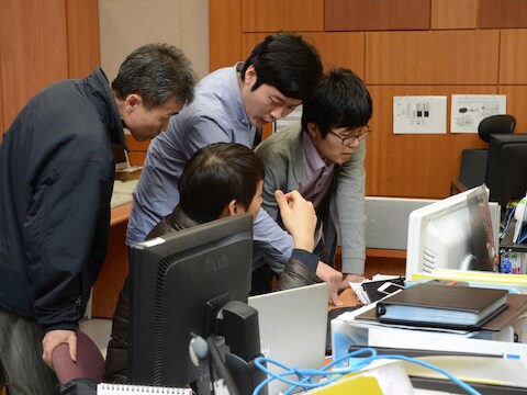 Medewerkers van de deze week door een cyberaanval getroffen Zuid-Koreaanse omroep KBS kijken op hun schermen wat er aan de hand is.