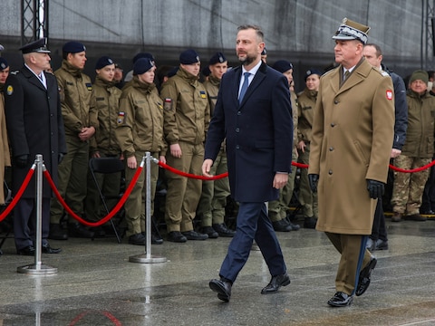 De Poolse defensieminister schouwt de troepen.