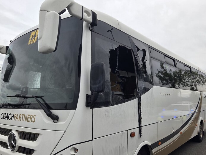 De ruit van de bus is ingeslagen. De politie onderzoekt of het om brandstichting gaat.