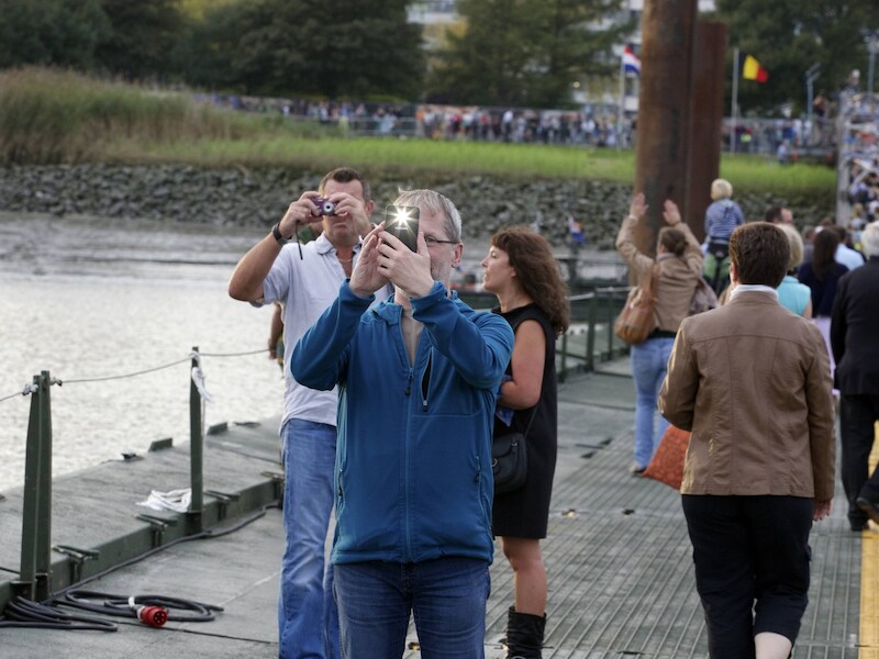 Bezoekers maken foto's op de pontonbrug over de Schelde.