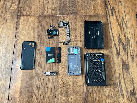 De verschillende onderdelen van de Fairphone 4, uit elkaar gehaald aan de hand van een schroevendraaierset van iFixit.