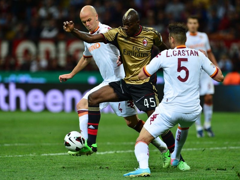 Balotelli wringt zich tussen twee verdedigers.